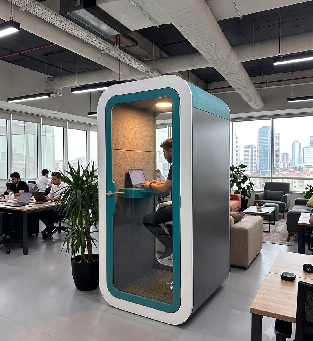 Person working inside a teal and white phone booth