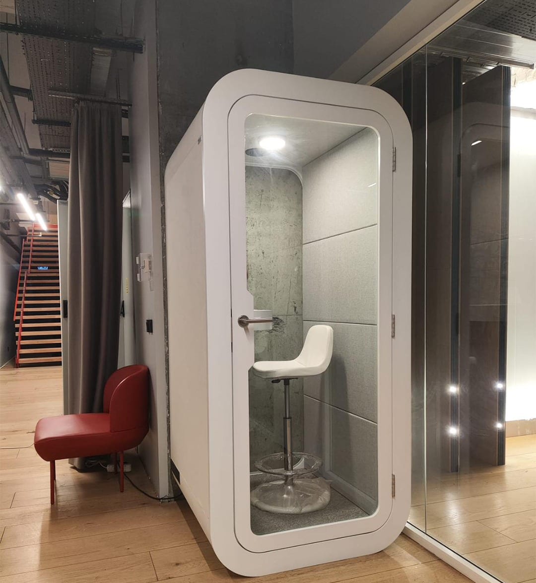 White phone booth with light grey acoustic panels and a white stool